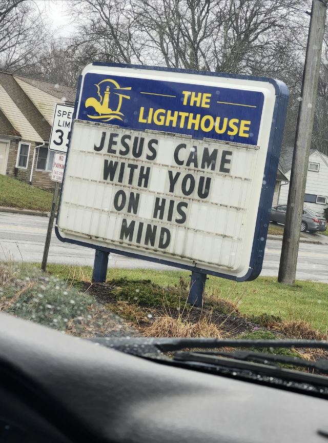 A church sign reads: "Jesus came with you on his mind." The background shows a street, trees, and a residential area