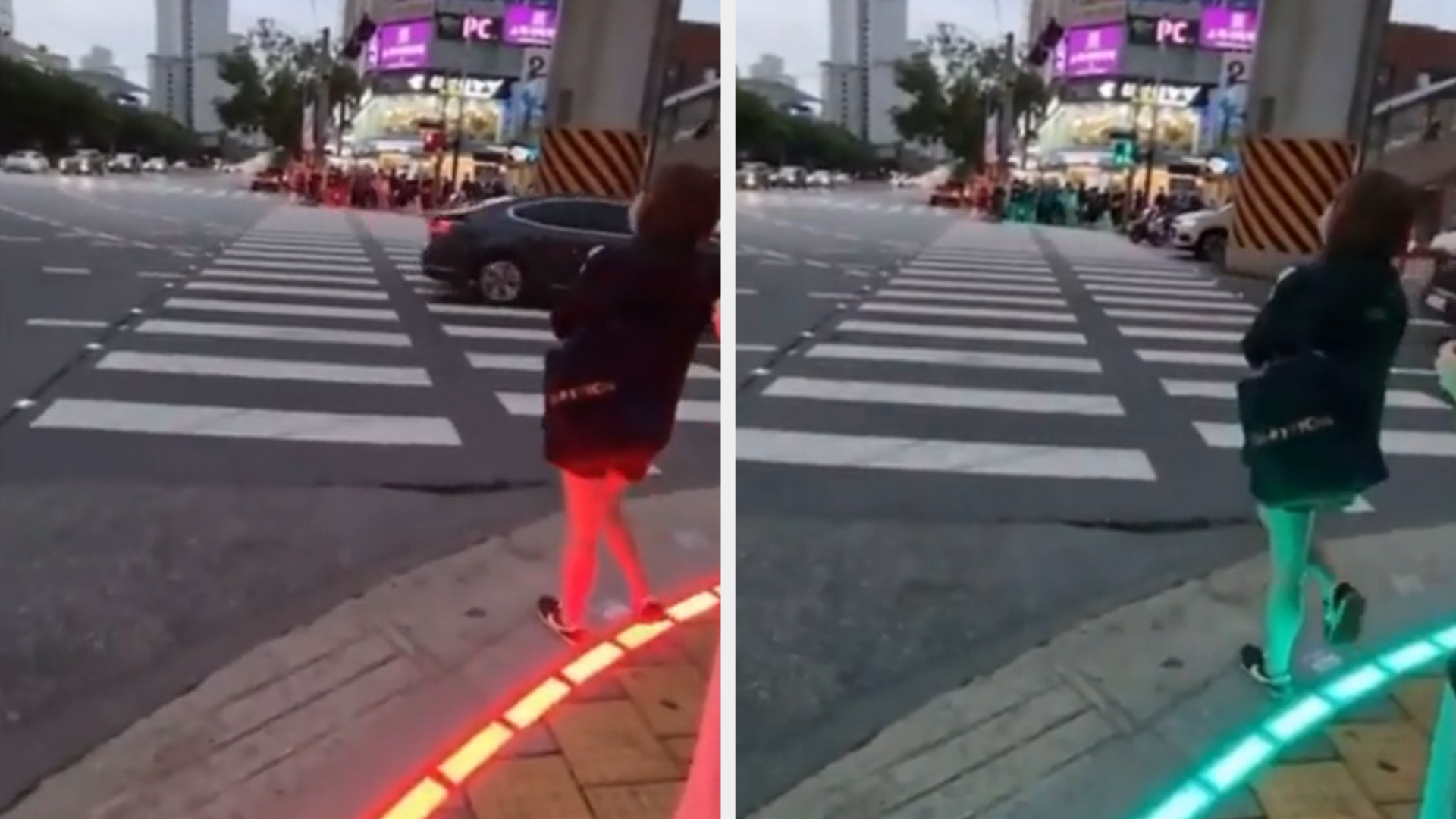 A person stands near a crosswalk in an urban area, with the ground lit up in red on the left and green on the right to indicate pedestrian crossing signals