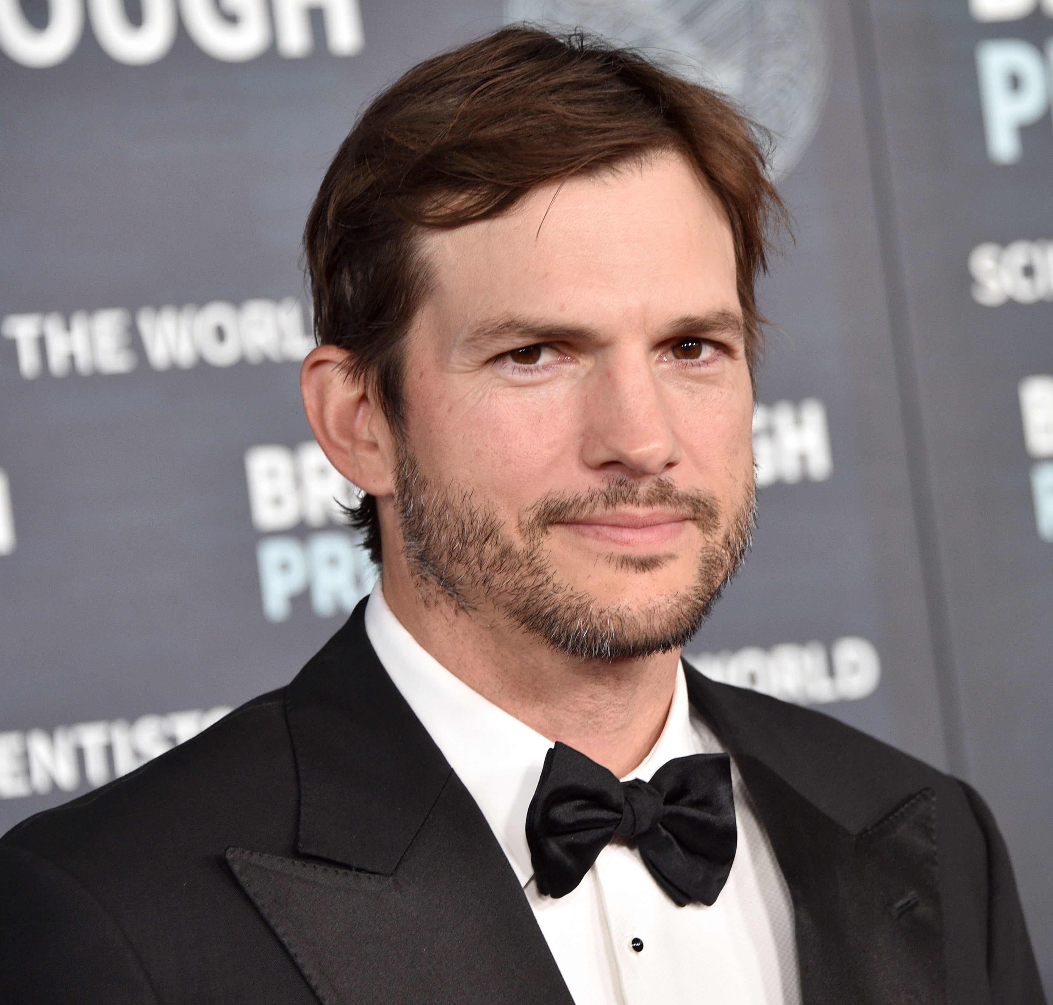 Ashton Kutcher at the Breakthrough Prize event, wearing a classic tuxedo with a bow tie