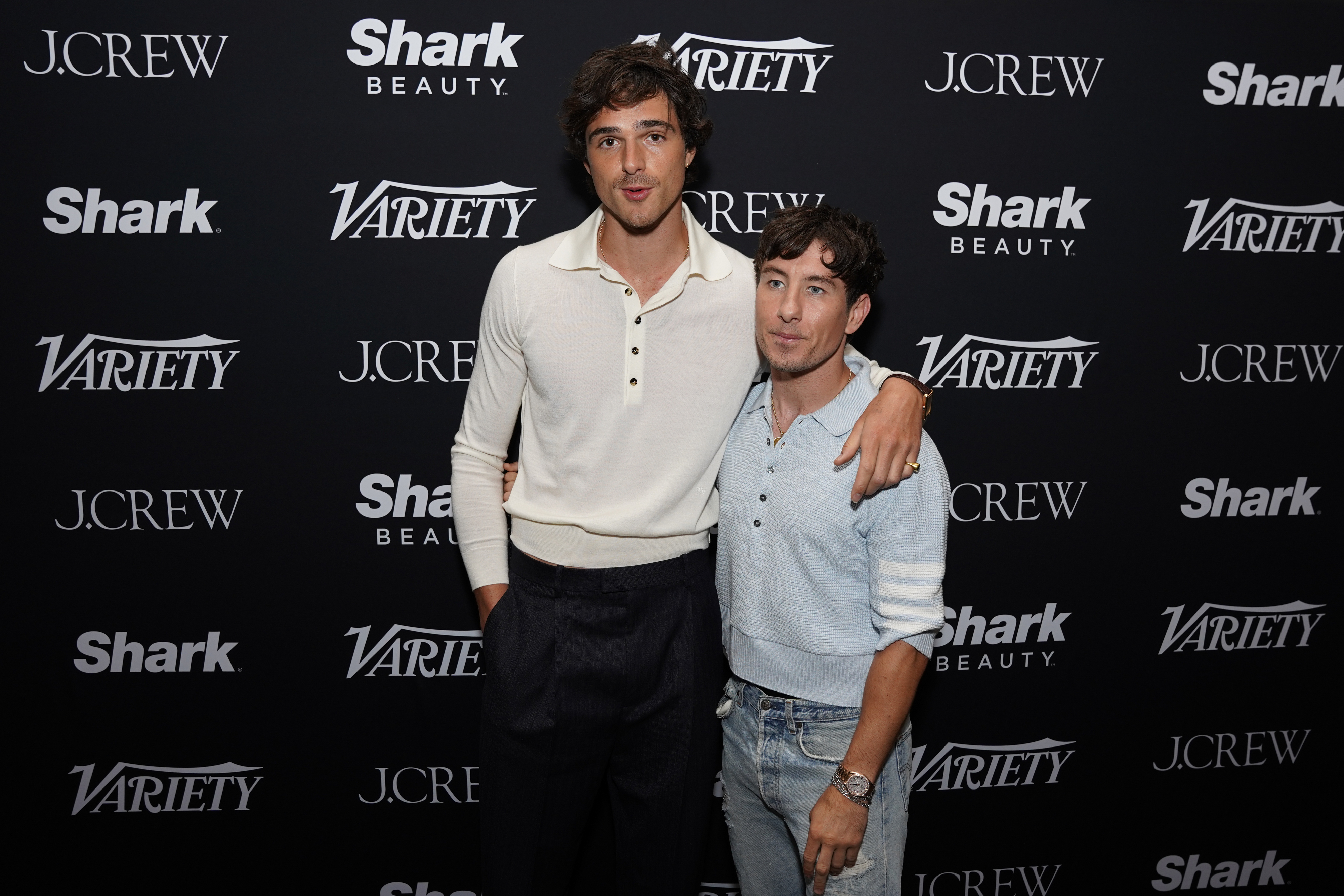 Jacob Elordi and Barry Keoghan pose together at a Variety event. Jacob wears a light long-sleeve shirt and dark pants, while Barry wears a light sweater and jeans