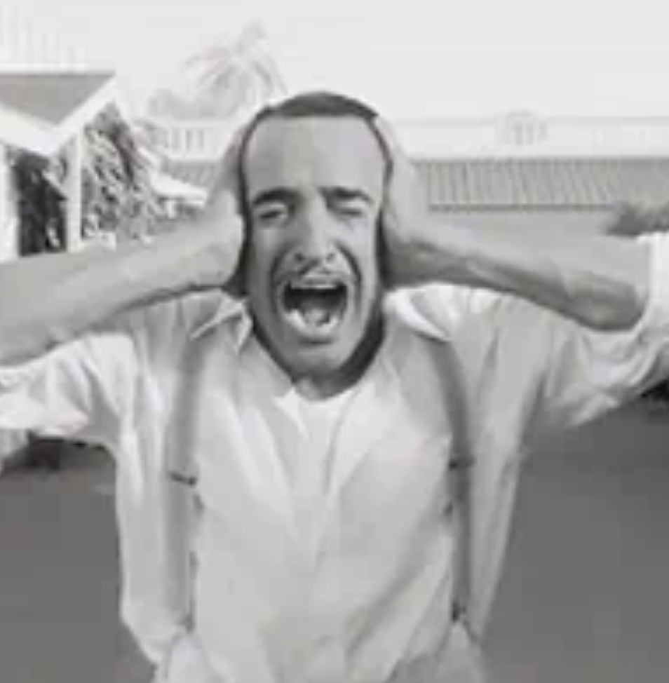 A man screaming with his hands on the side of his head