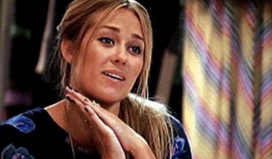 Lauren Conrad smiling with her hands under her chin, wearing a patterned top