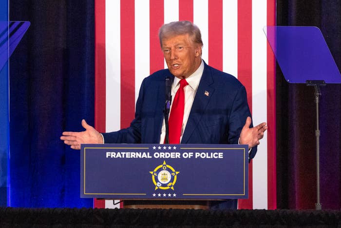 Donald Trump speaks at a podium labeled "Fraternal Order of Police" with a backdrop of vertical stripes