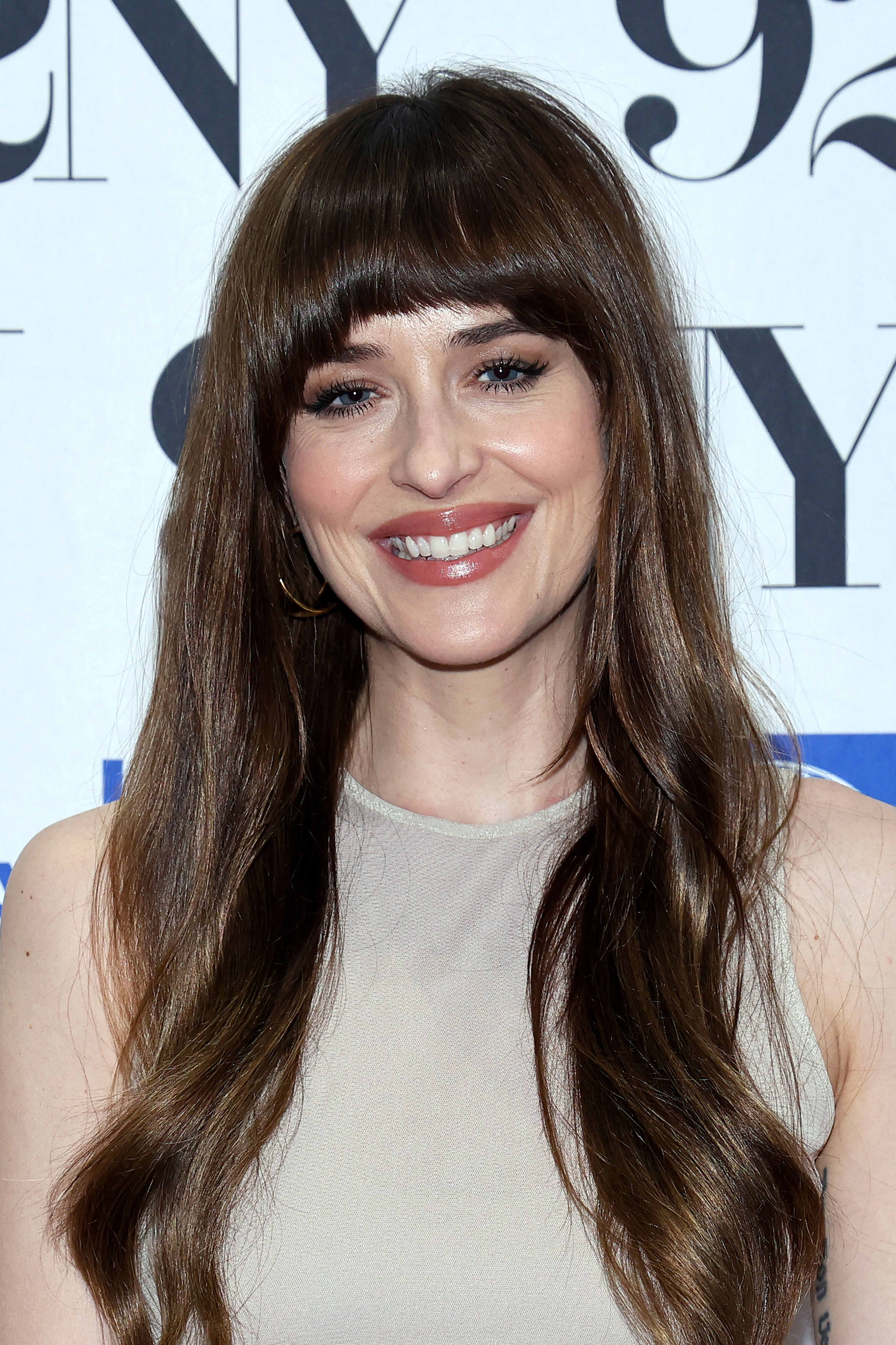 A woman with long brown hair smiling at an event