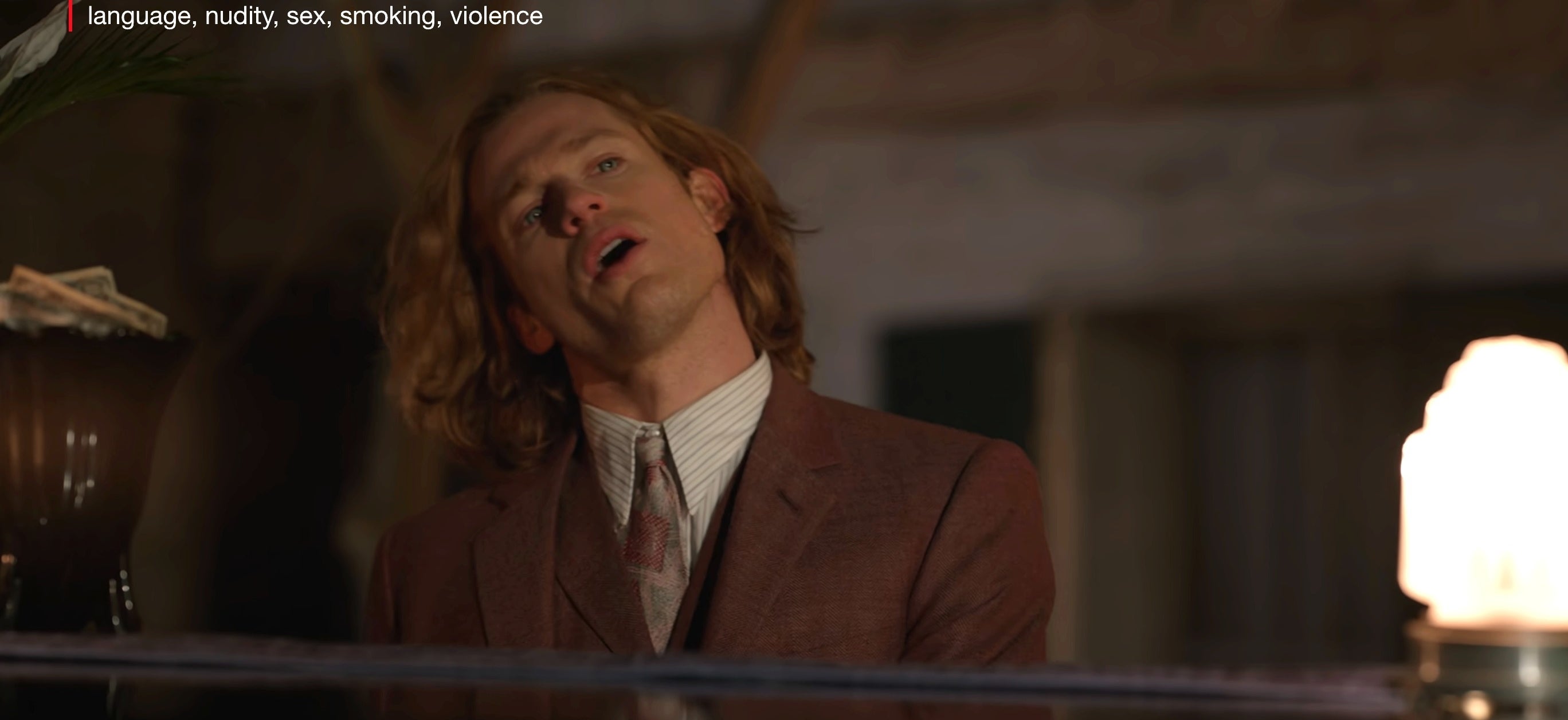 Lestat wearing a suit playing piano