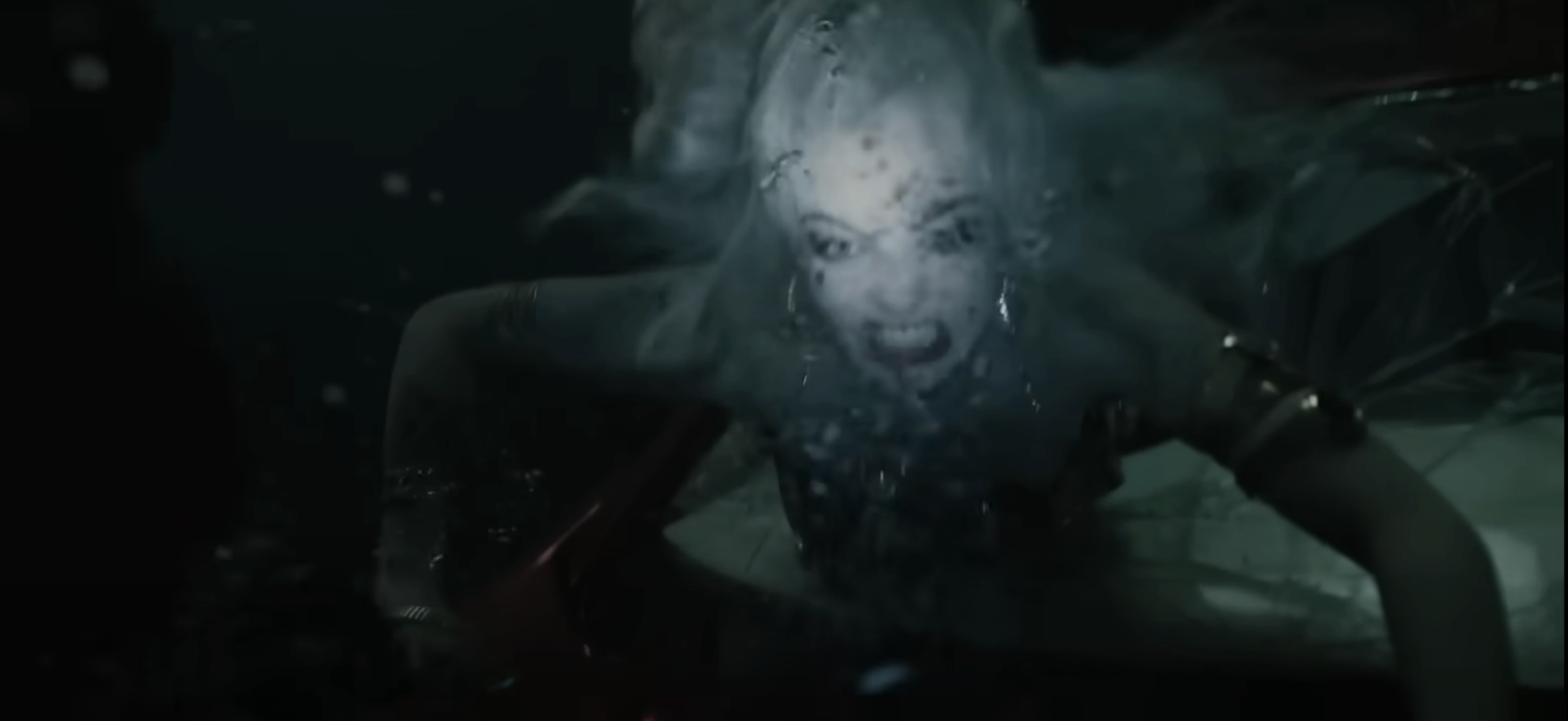 Margot Robbie as Harley Quinn underwater, looking fierce and determined, reaching out from a submerged car in a dramatic scene