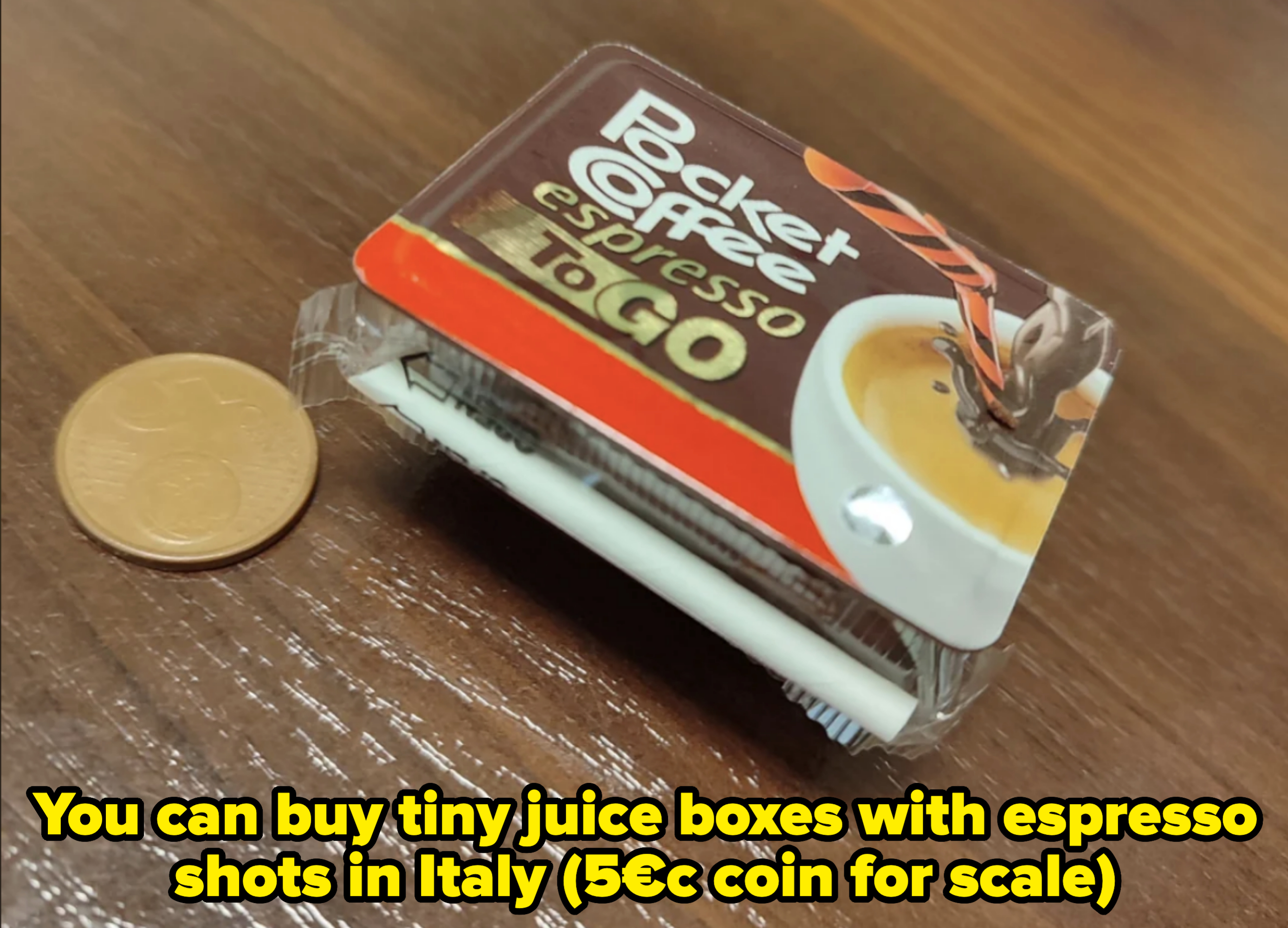 Packet of Pocket Coffee espresso ToGo next to a coin for scale, placed on a wooden surface