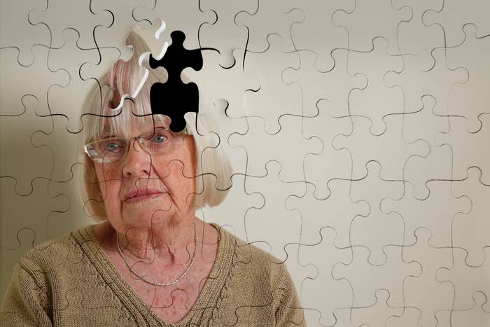 An elderly woman with gray hair and glasses is depicted as a puzzle with a missing piece over her head