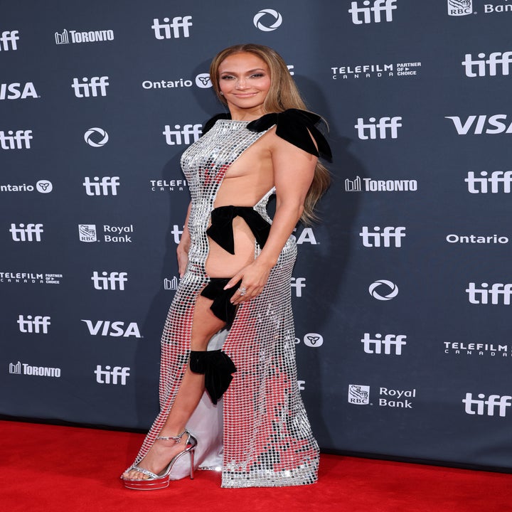 Jennifer Lopez on the TIFF red carpet wearing a high-slit, metallic gown with black bow details