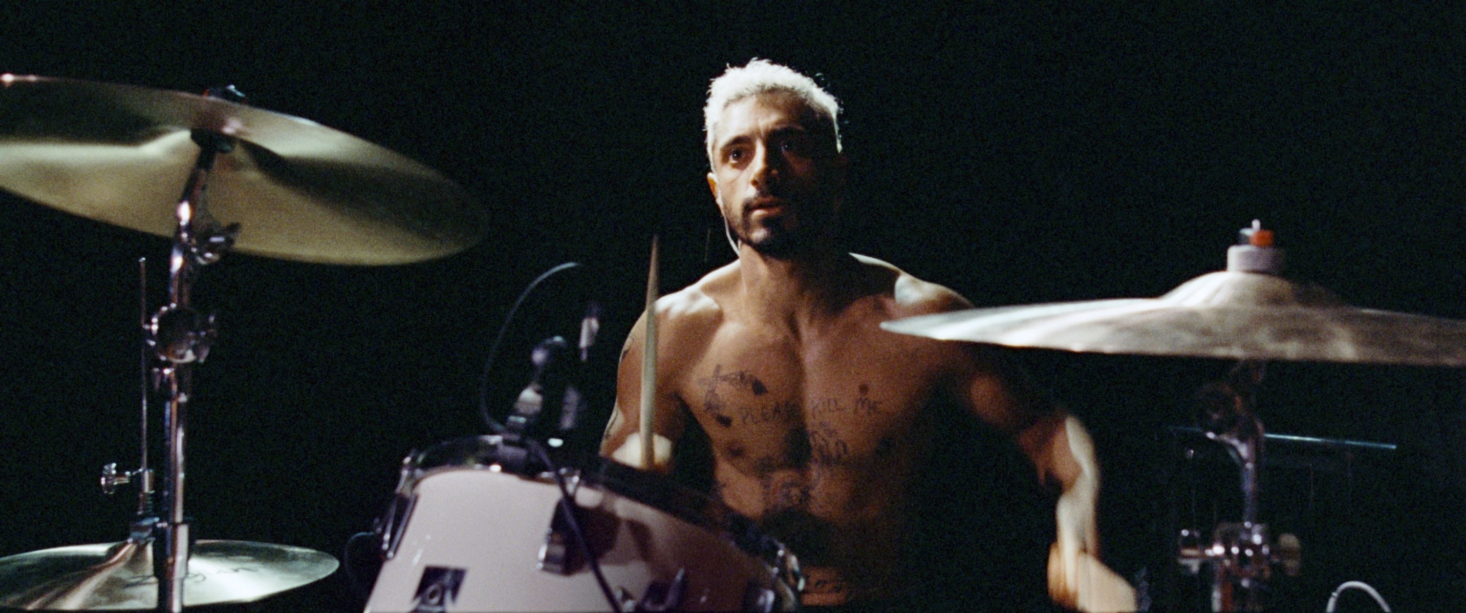 Riz Ahmed, shirtless and drumming intensely in the movie &quot;Sound of Metal.&quot;