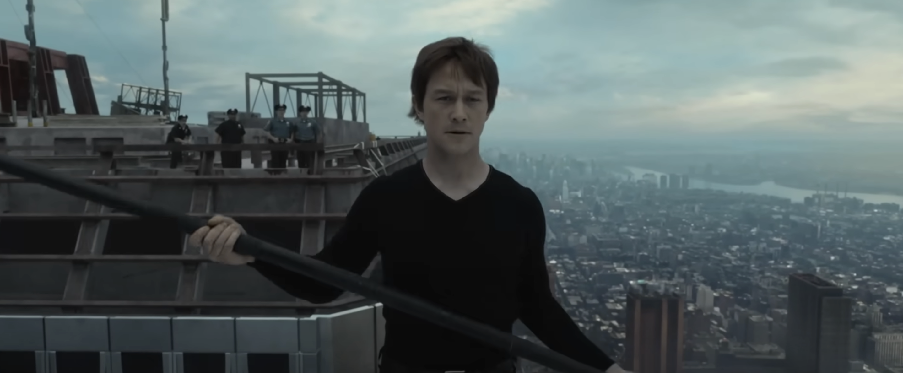 Joseph Gordon-Levitt, dressed in a long-sleeve shirt, walks on a tightrope between skyscrapers over a city in a scene from the movie &quot;The Walk&quot;