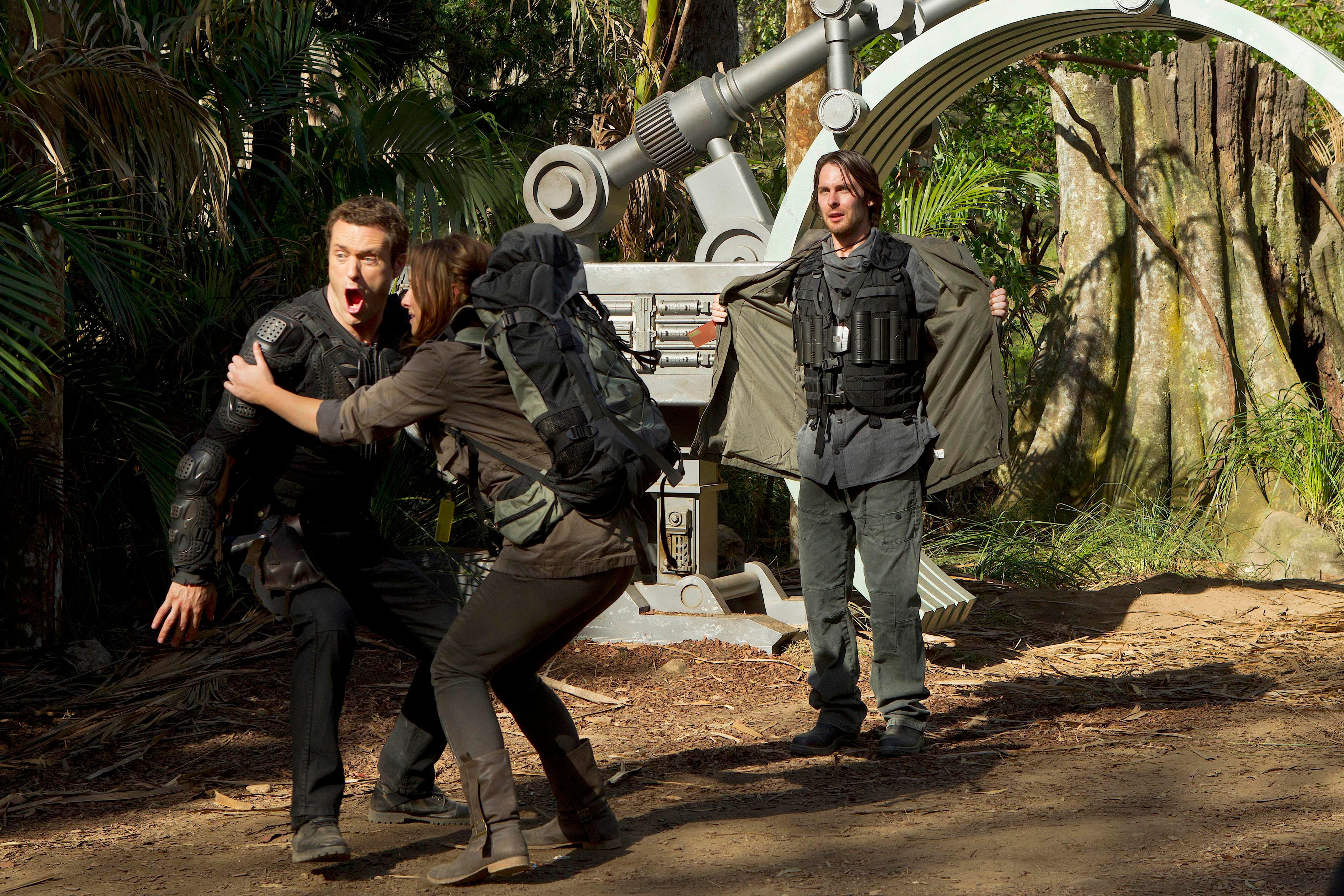 Jason O'Mara, Shelley Conn, and Landon Liboiron in outdoor scene with advanced machinery, O'Mara and Conn in tactical gear, Liboiron with arms out, surprised