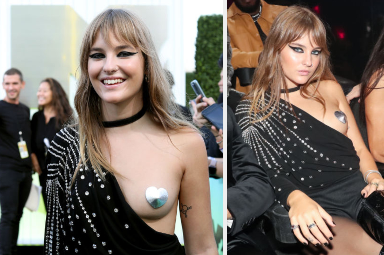 Victoria at a celebrity event in a stylish, one-shoulder black outfit with studded embellishments and a metallic heart-shaped chest accessory