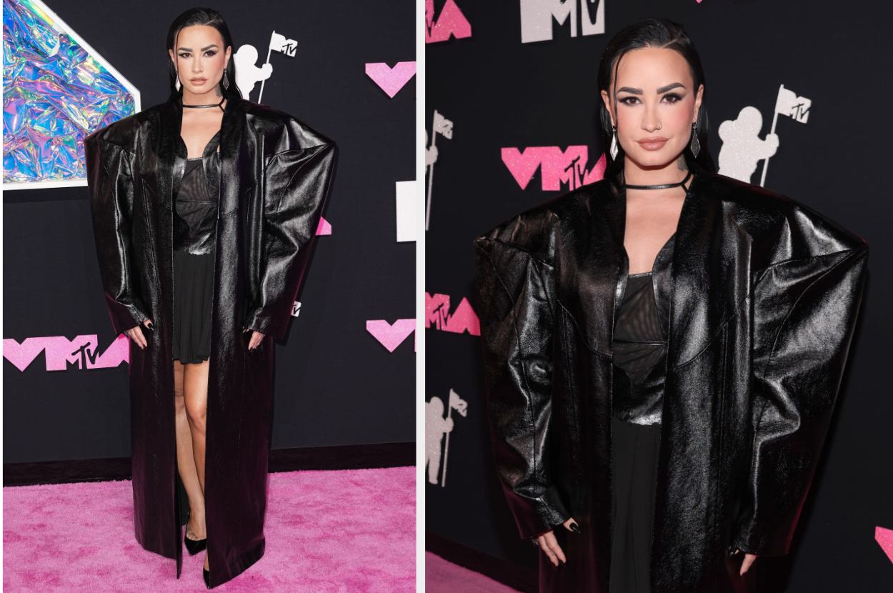 Demi Lovato at the MTV event, wearing a voluminous, oversized black leather coat over a chic black outfit