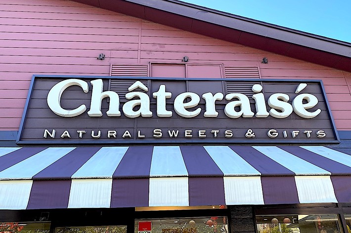 The image shows the exterior of a Châteraisé store with a sign reading &ldquo;Châteraisé Natural Sweets &amp; Gifts&rdquo; above a striped awning