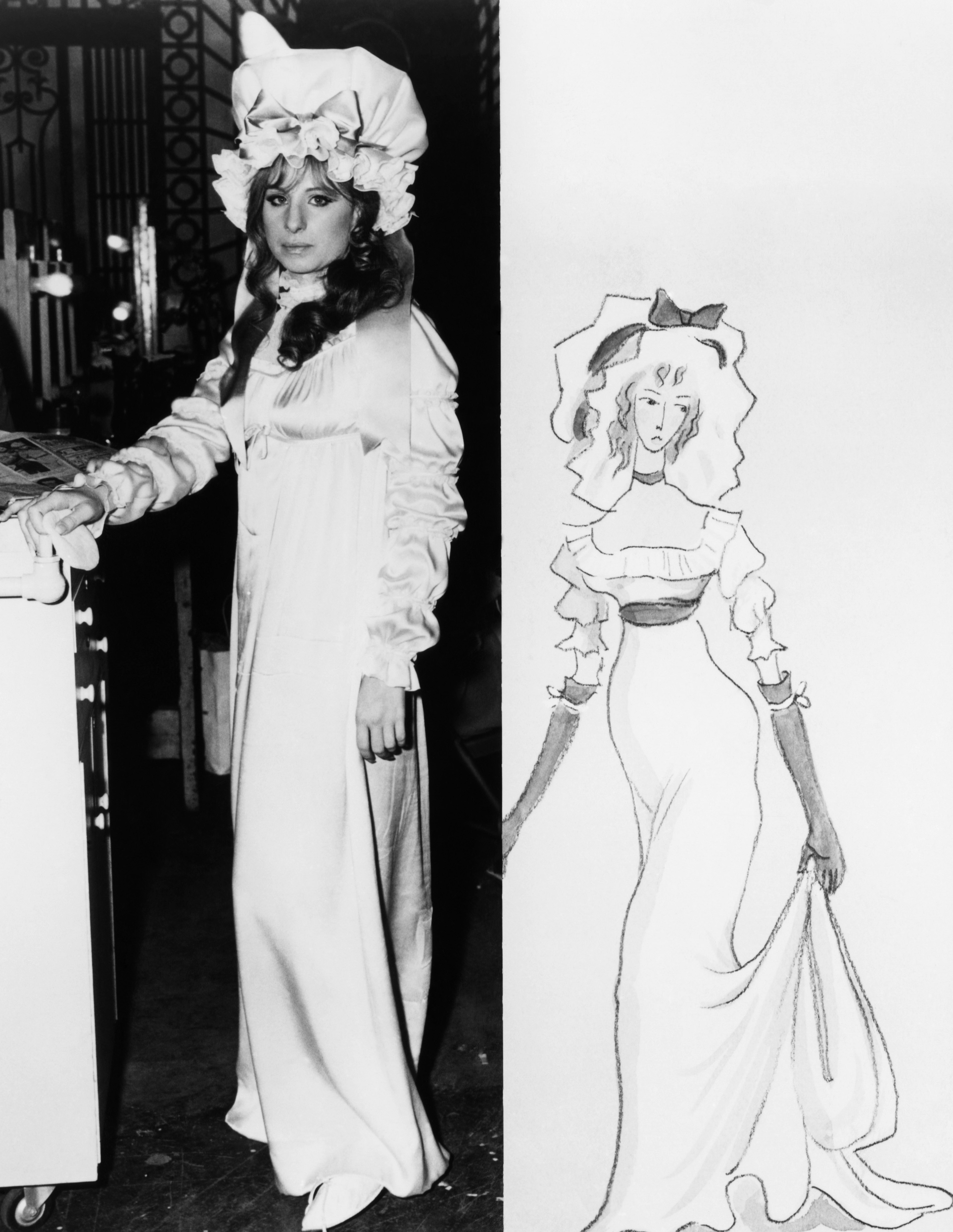 Barbra Streisand stands next to a sketch of a woman in a similar victorian-style dress with a bonnet