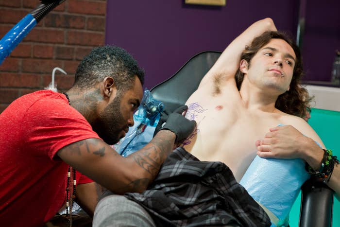 Tattoo artist tattooing a man's ribcage on "Best Ink"