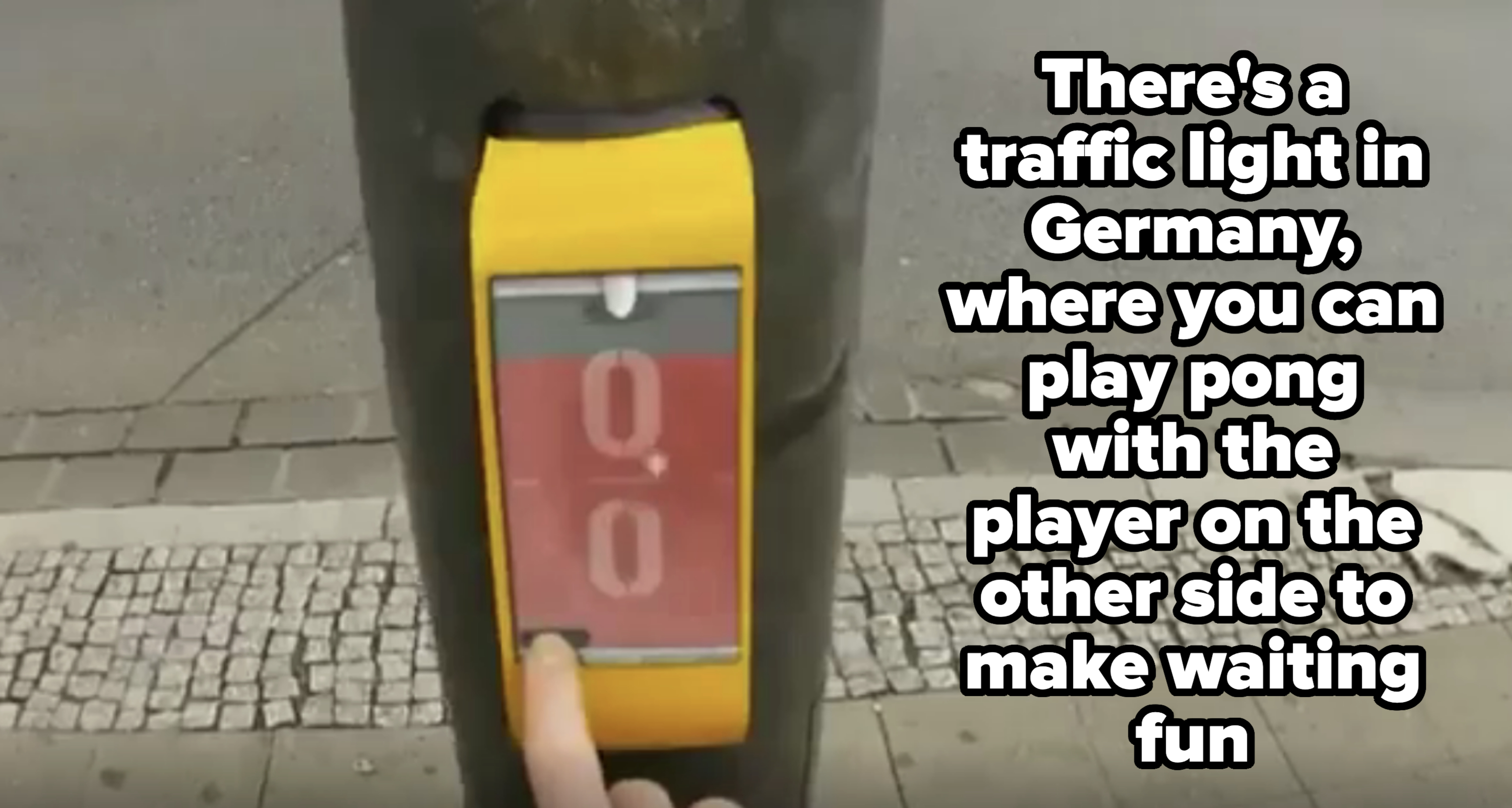 A finger presses a yellow pedestrian crossing button with a digital countdown timer showing 0.0