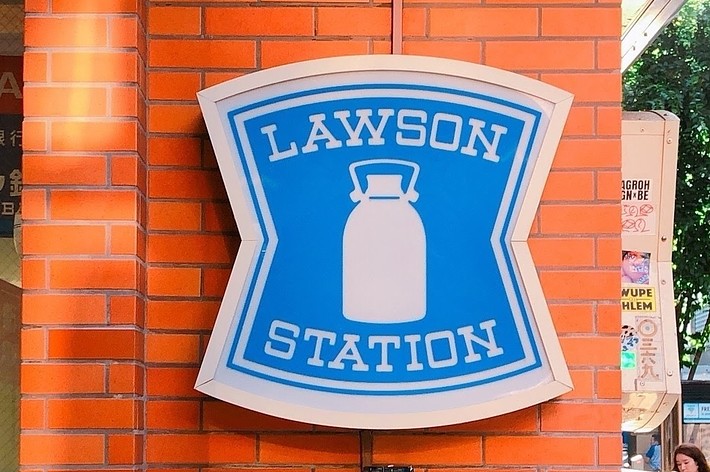 ローソンの看板。ロゴには牛乳瓶のデザイン。下部の表示は「OPEN 24 HOURS」と書かれている。