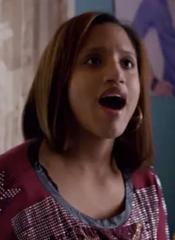young Daya has an expression of surprise or excitement. She wears a shirt with metallic details and large hoop earrings