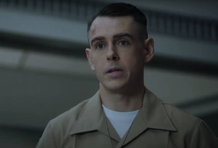 young Gibbs is seen with a slight injury on his forehead, wearing a uniform and speaking seriously