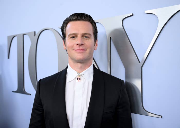 Jonathan Groff in a classic dark suit and white shirt at a Tony Awards event