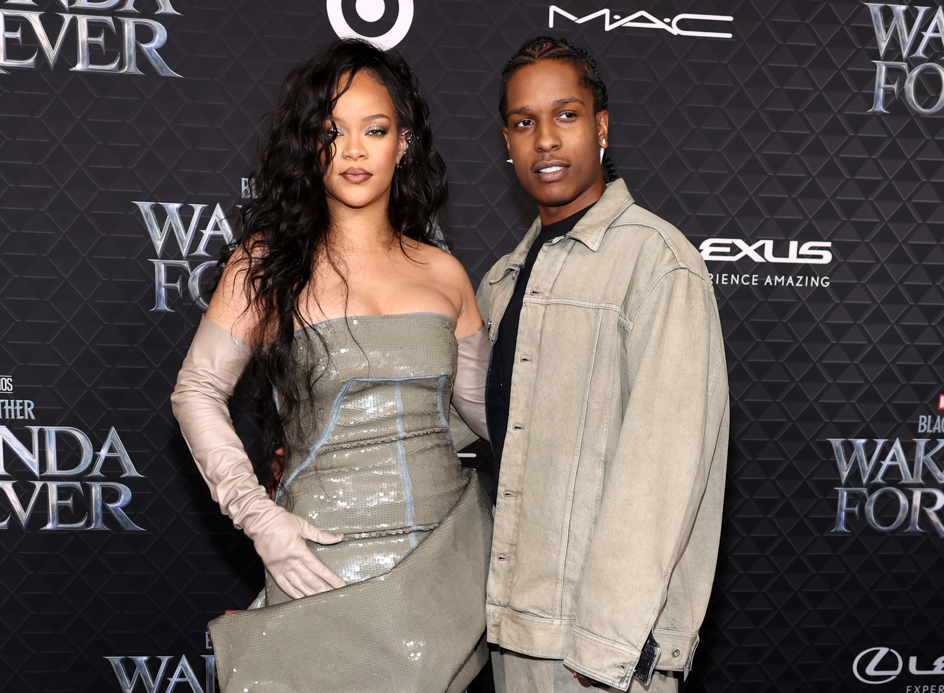 Rihanna and ASAP Rocky on a red carpet: Rihanna in a strapless shiny gown and gloves, Rocky in a casual jacket and pants