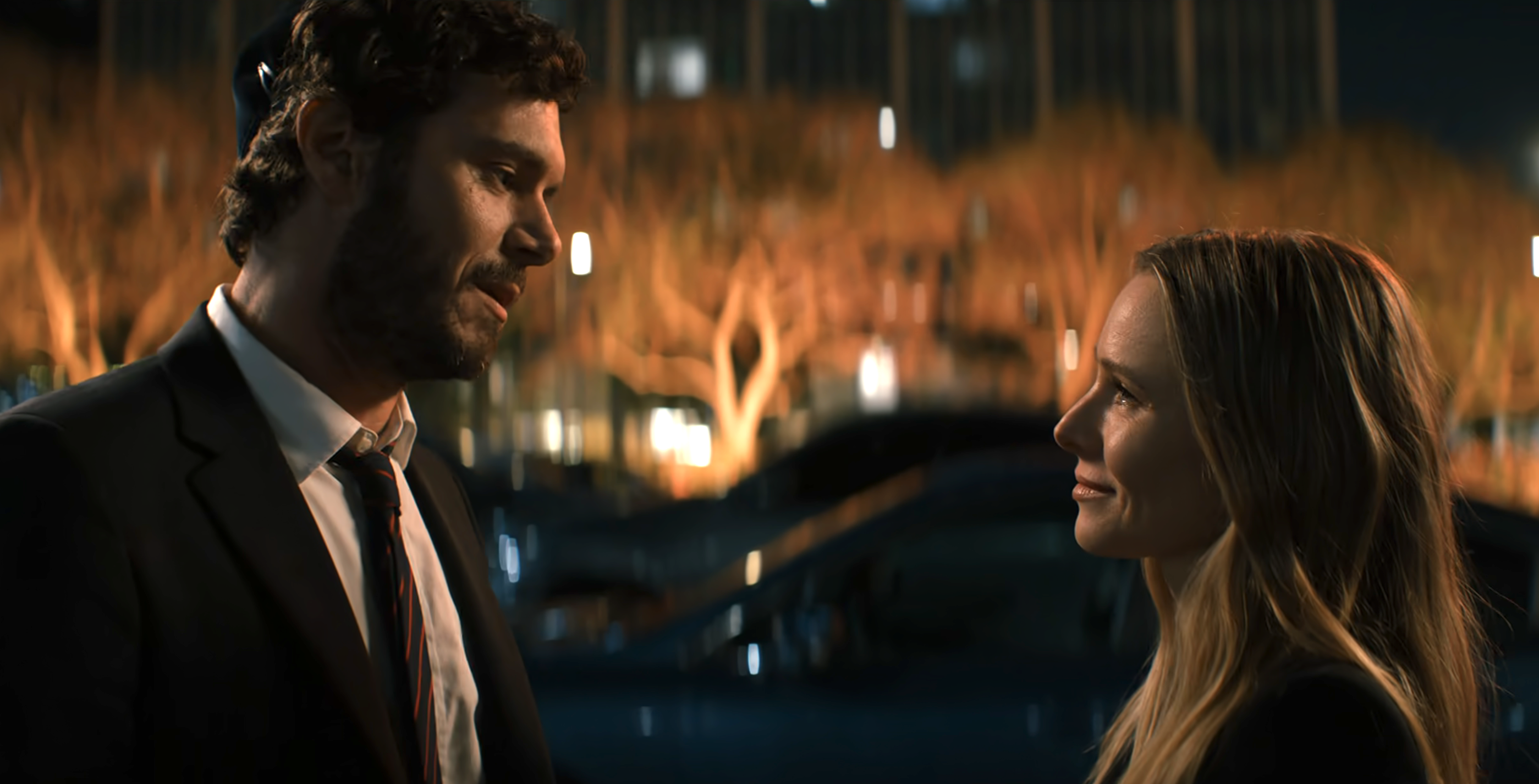Adam Brody and Kristen Bell stand outside, looking at each other, in a scene from &quot;Nobody Wants This.&quot; They are dressed in formal attire
