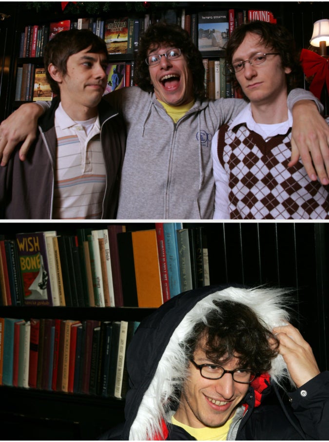 Three men posed in front of a bookshelf. One photo shows them standing; the other features a man adjusting his hood with a smile. Clothing is casual