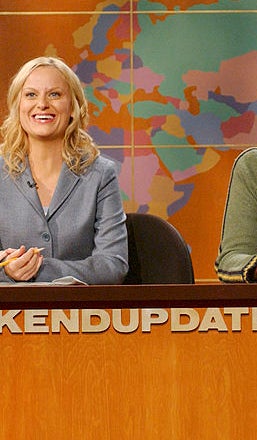 Four people sit at a &quot;Weekend Update&quot; desk