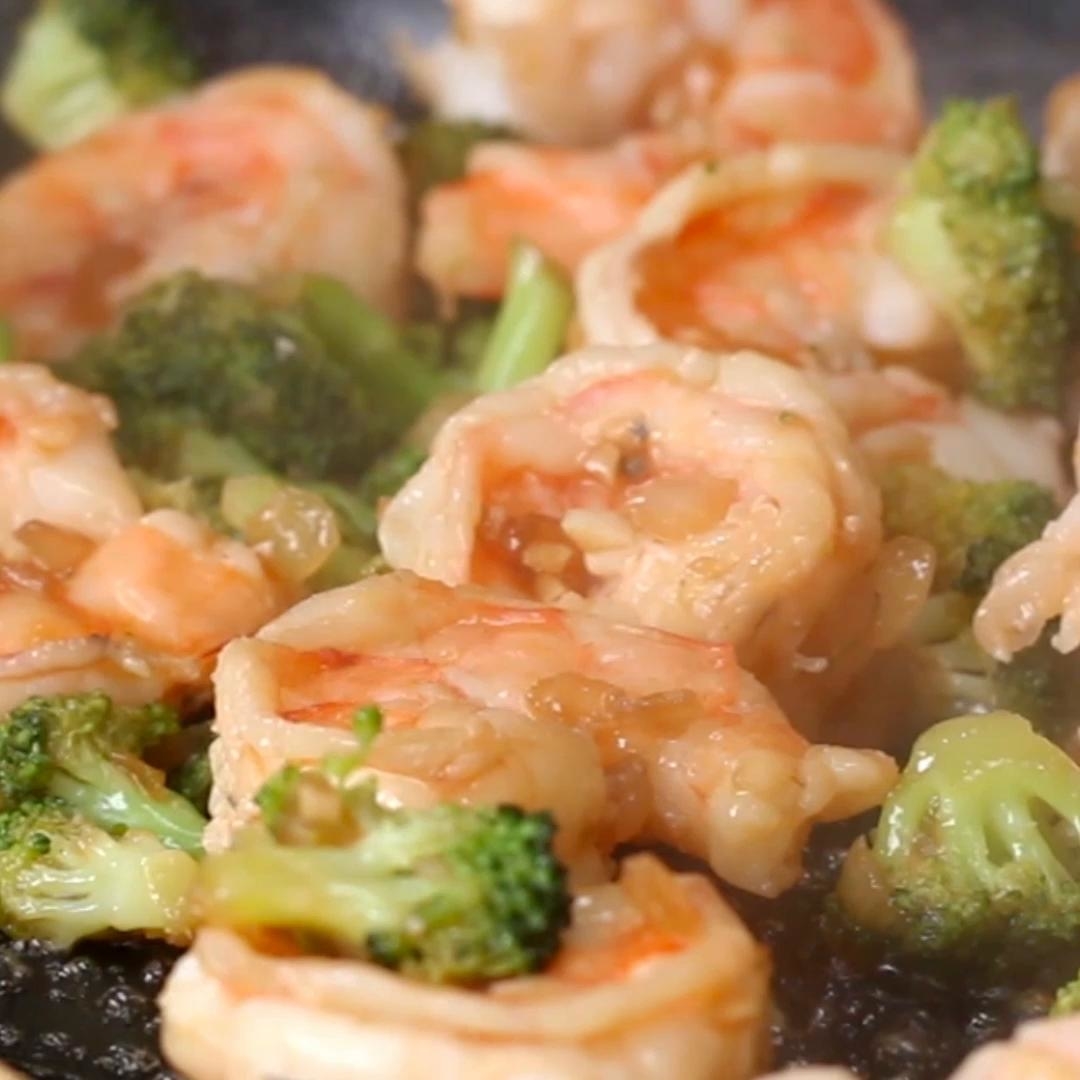 Sautéed shrimp and broccoli in a pan, showcasing a delicious stir-fry dish with visible garlic and seasoning