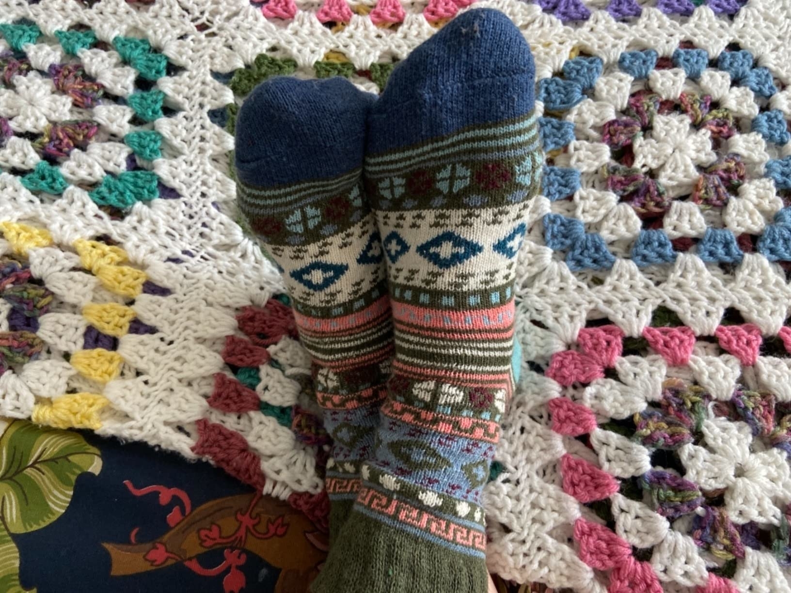 Cozy patterned socks on a colorful crocheted blanket