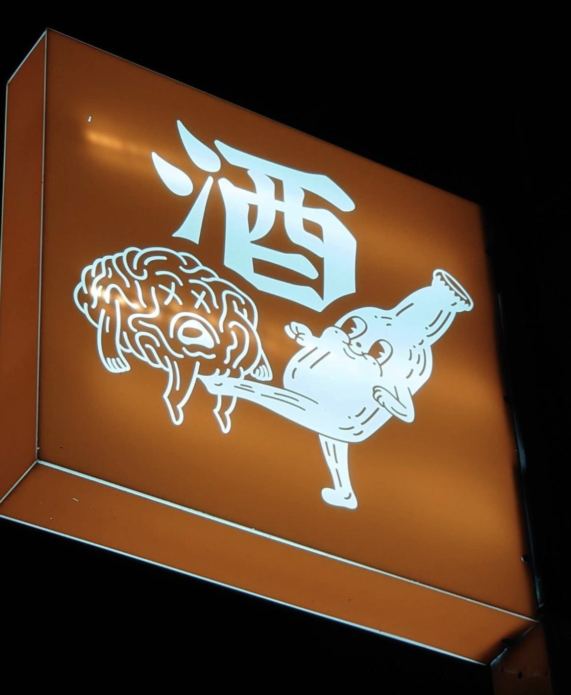 Sign with cartoon alcohol bottle kicking a brain. Contains Japanese kanji for alcohol, &quot;酒.&quot;