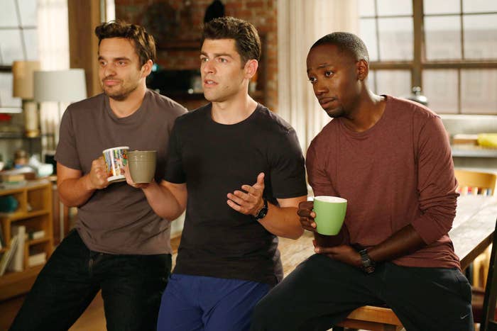 Three men, casually dressed, drinking coffee in an apartment setting