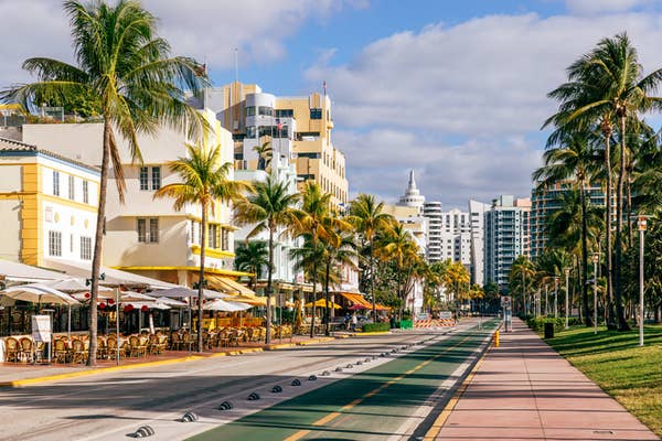 Ocean Drive in Miami Beach, with art deco buildings, outdoor cafes, palm trees, and a bike path