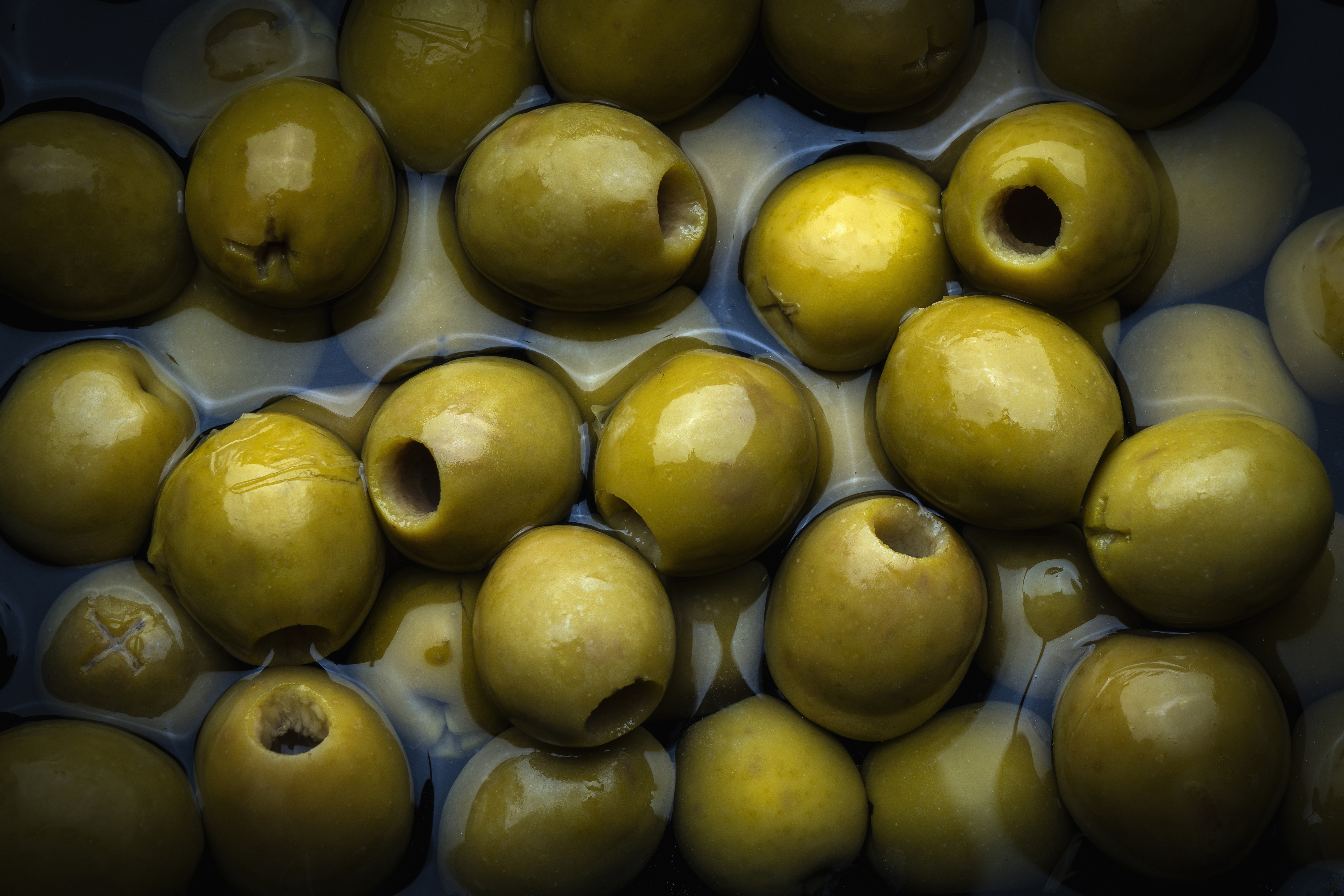 Close-up of green olives submerged in liquid