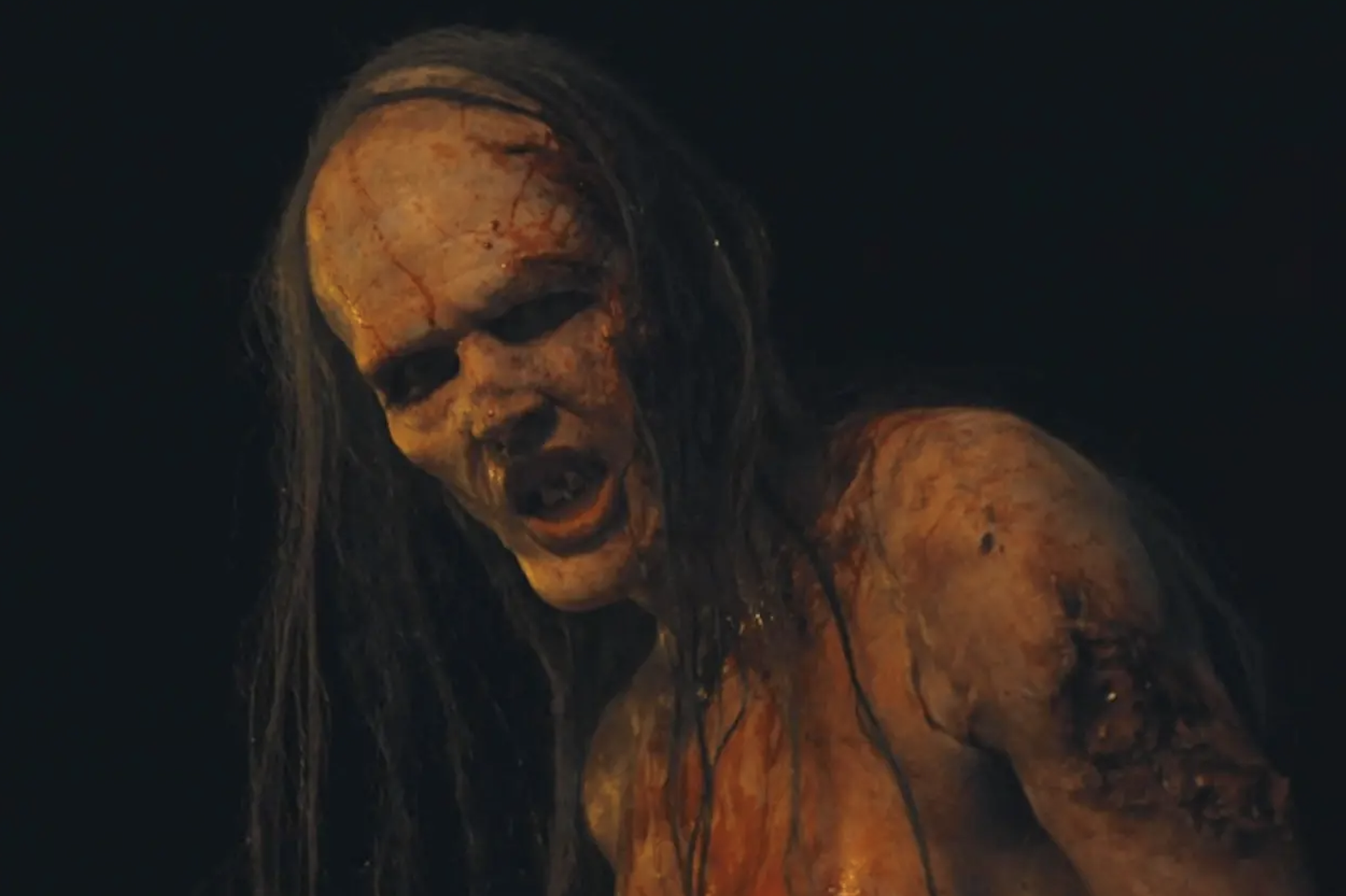 A terrifying zombie from &quot;The Last of Us&quot; with rotting skin and long hair snarls menacingly