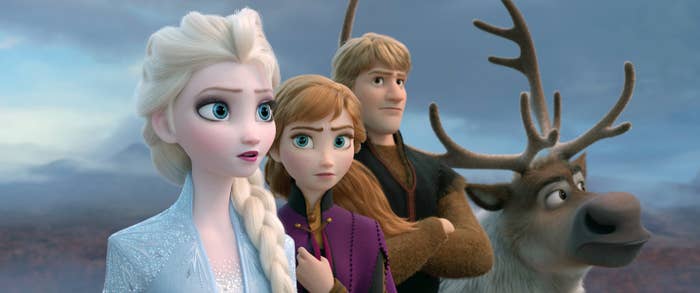 Elsa, Anna, Kristoff, and Sven stand together, looking into the distance, from the movie Frozen. Elsa and Anna are in winter outfits