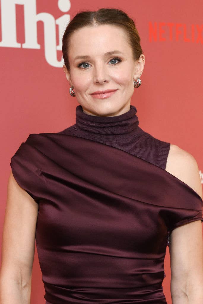 Woman in a sleek, off-shoulder outfit at a red carpet event