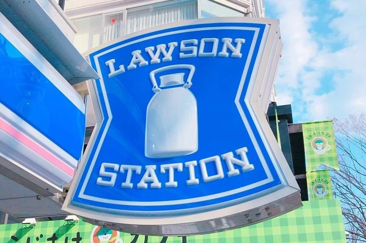 ローソンの看板が店舗の外にある。背景にはビルと青空が見える。