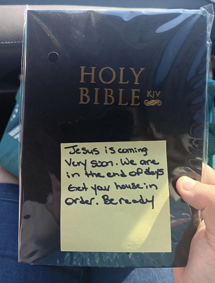 A hand holds a copy of the Holy Bible KJV with a sticky note saying, &quot;Jesus is coming very soon. We are in the end of days. Get your house in order. Be ready.&quot;