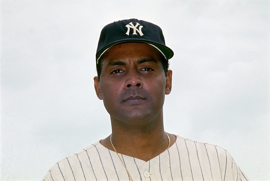 close up of Rubén Sr in a baseball shirt, Yankees cap, and gold chain