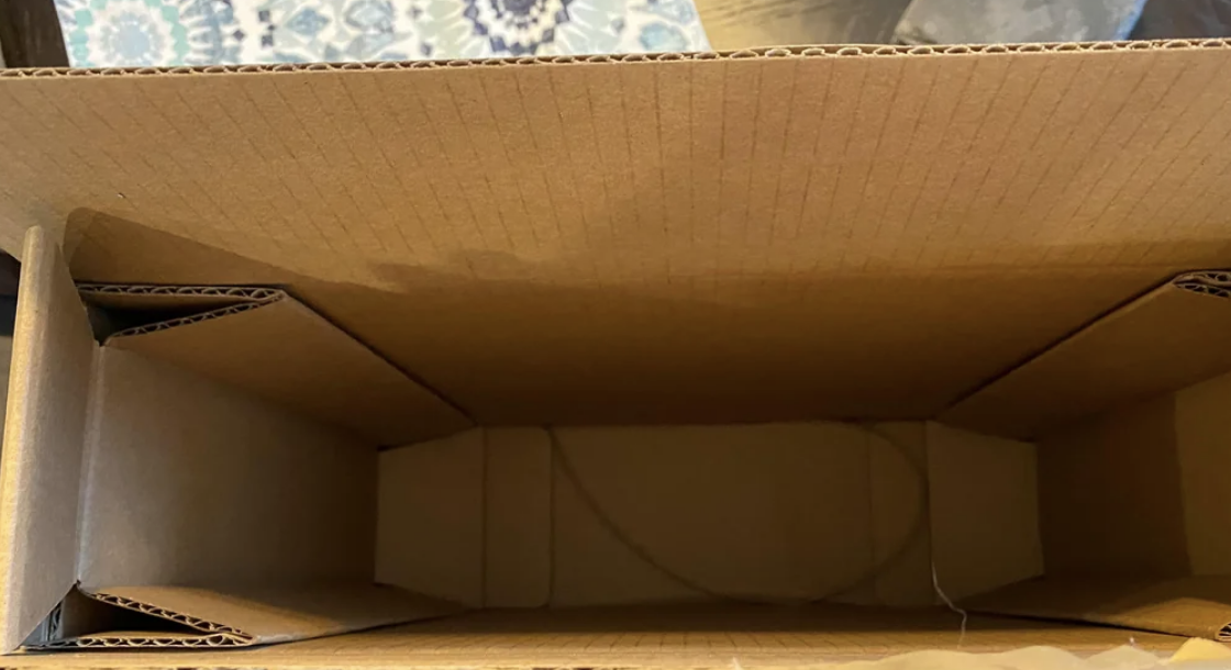 Open cardboard box showing the interior with flaps slightly bent inward