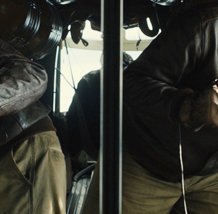 close up of Stephen in uniform and goggles, looking out the window in a military scene