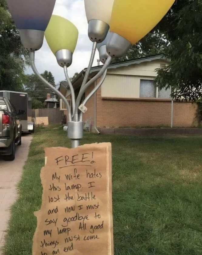 Free standing lamp on curb with sign saying, &quot;FREE! My wife hates this lamp. I lost the battle and now I must say goodbye to my lamp. All good things must come to an end.&quot;