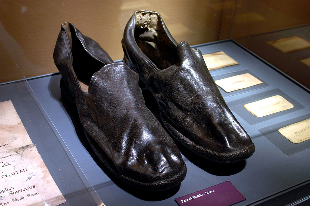 A pair of worn leather shoes displayed in a museum exhibit, titled &quot;Pair of Robber Shoes.&quot;