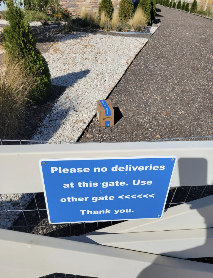 Sign says, &quot;Please no deliveries at this gate. Use other gate. Thank you.&quot; A package is left by the gate despite the message