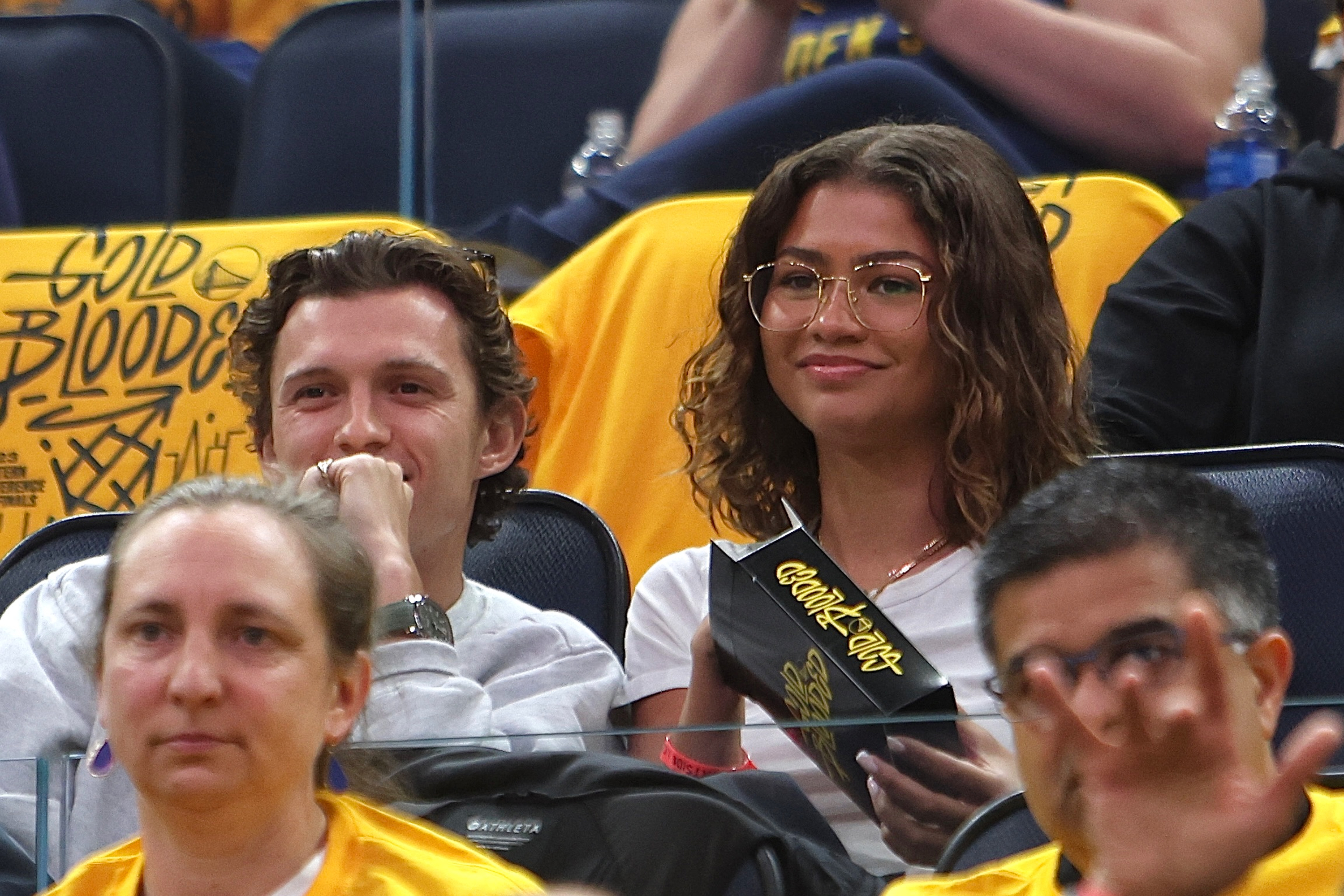 Tom Holland and Zendaya watch a sporting event from their seats