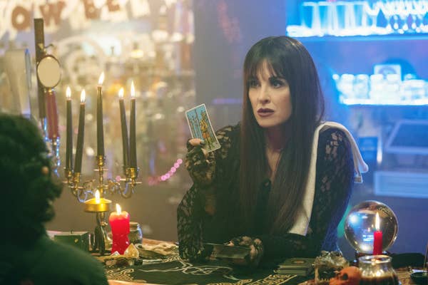 Kyle Richards holding a tarot card in a spooky shop setting in &quot;Halloween Ends&quot;