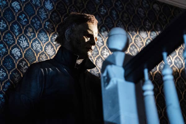 James Jude Courtney dressed as Michael Myers against a patterned wall in &quot;Halloween Ends&quot;